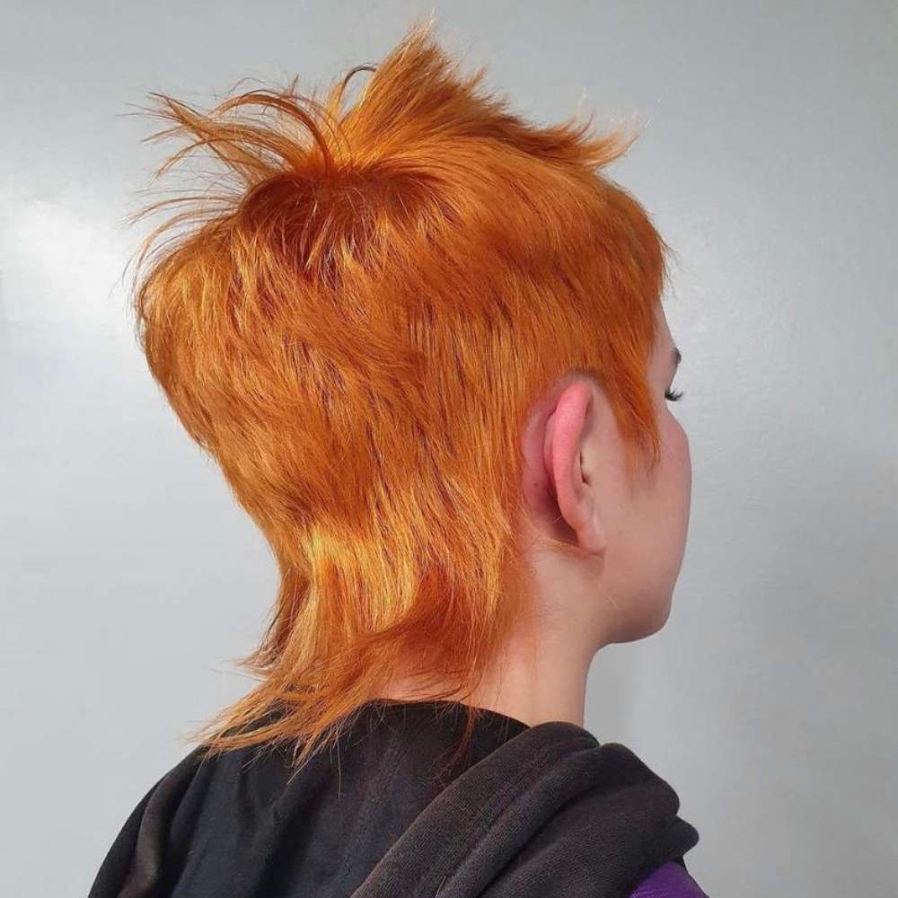 taglio di capelli mullet color arancio con coda e basette lunghe